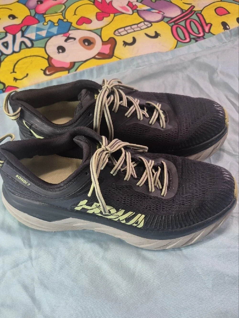 Hoka black running shoes with pale yellow logo